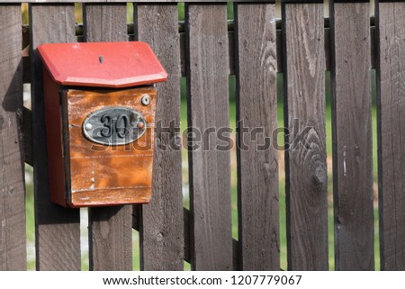 House number 30 on the mailbox on old wooden fence in a remote village