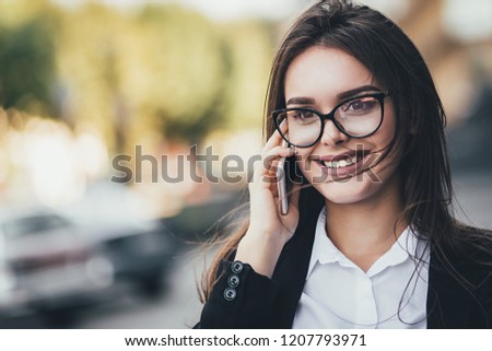 Attractive brunette businesswoman talking on mobile phone with client. Close up