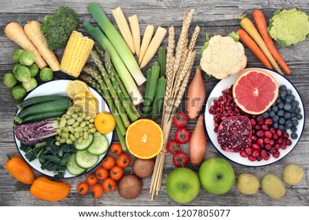 High fibre super food concept with fresh fruit and vegetables and wheat sheaths. High in anthocyanins, antioxidants, minerals  and vitamins. Top view on rustic wood background. Royalty-Free Stock Photo #1207805077
