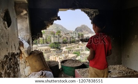 Child inspects their destroyed house due to the war in Yemen... Royalty-Free Stock Photo #1207838551