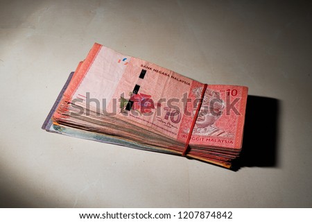 A stacks of Ringgit Malaysia Notes in the dark.