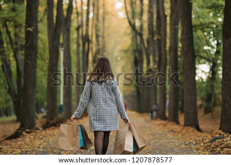 Girl walking after shopping. Woman carrying bags after shopping