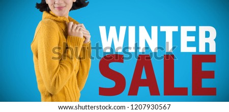 Woman in winter clothing posing against white background against blue background