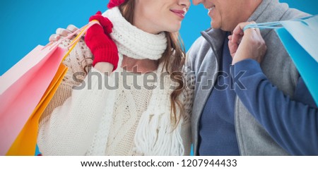 Couple with shopping bags against blue background
