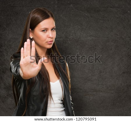 Young Woman Showing Stop Hand Gesture against a grunge background