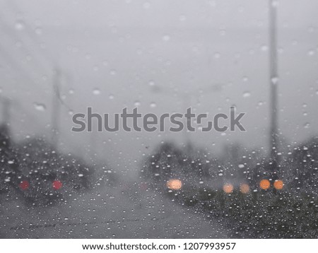 Raining while driving on a road with lots of vehicles.