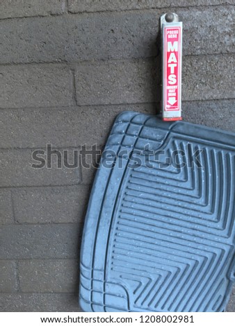 Car wash mat clip with rubber car mat hanging in washing bay
