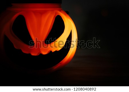 Halloween pumpkin Jack-o'-lantern with scary glowing face on black background, isolated. Glowing spooky pumpkin face in dark. Space for text. 