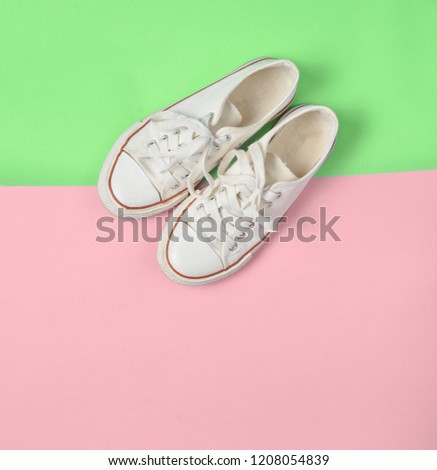 Old retro sneakers with white laces on a blue pink pastel background. Minimalism. Top View

