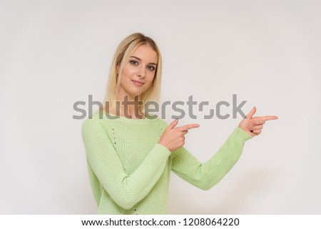 Photo portrait of a beautiful blonde girl talking on a white background with different emotions. She is standing right in front of the camera, smiling and looking happy.