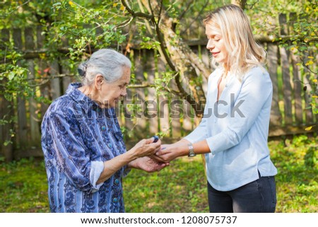 Picture of elderly woman in blue dress spending quality time with beautiful granddaughter