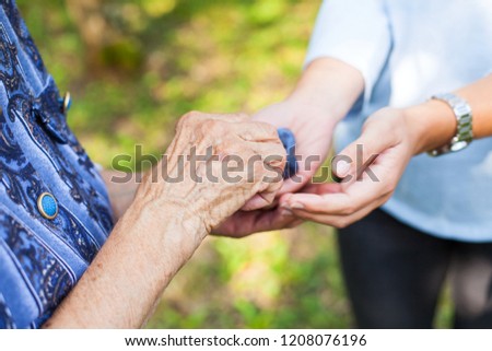 Close up picture of wrinkled elderly hand and a handful of medication and vitamins