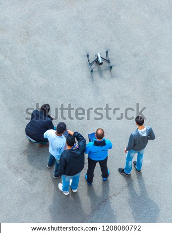 The unrecognizable person, camera operator and pilot with the controls panels teach to manage and use the drones of other new owners quadcopter UAV`s drone for commercial aerial photography.