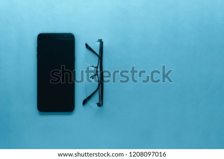 Gadget and glasses isolated on a blue background 