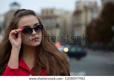 Closeup portrait of magnificent brunette model with long hair posing in the evening city. Space for text