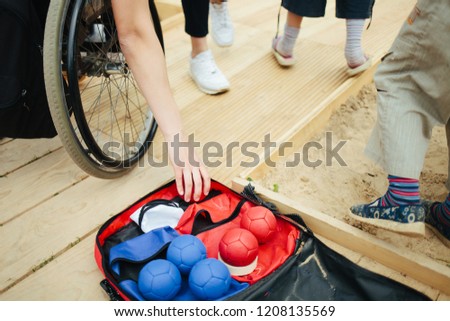 People with disabilities play croquet. A group of disabled people playing croquet together. Friends of disabled people have fun on the beach. Inclusive environment. Croquet balls in the background Royalty-Free Stock Photo #1208135569