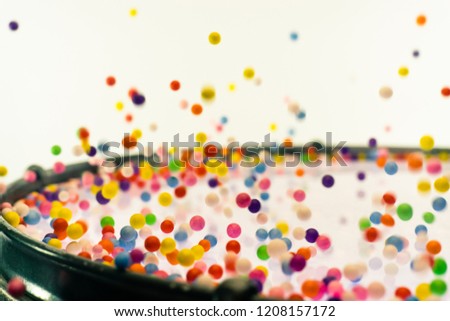 Colored balls bounces off drum in shockwave pattern. White backg