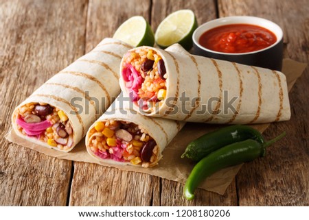Dietary grilled vegetarian burrito with rice and vegetables close-up on the table. horizontal
