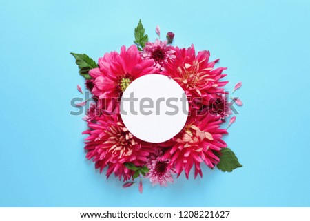 Flat lay composition with beautiful dahlia flowers and blank card on color background