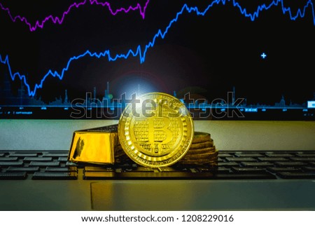 The golden bitcoin is stacked on keyboard and graph index background, Conceptual image for worldwide crypto currency, huge stack physical version of golden bitcoin, finance concept.