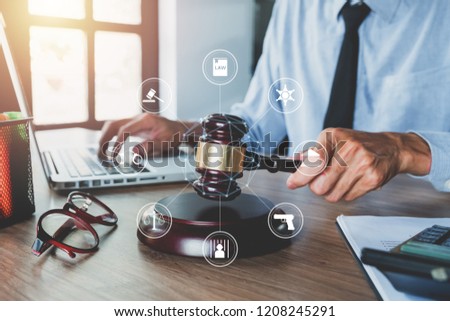 Male judge working with laptop computer, legal books and gavel on white wooden table in courtroom.justice and law concept with virtual interface icons network diagram.