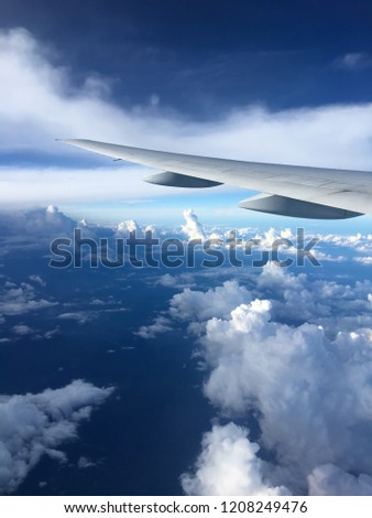 The wing of Being777 above the clouds and blue bright sky 