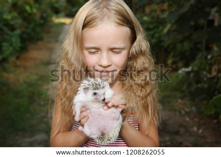 beautiful little girl with her pet African pygmy hedgehog