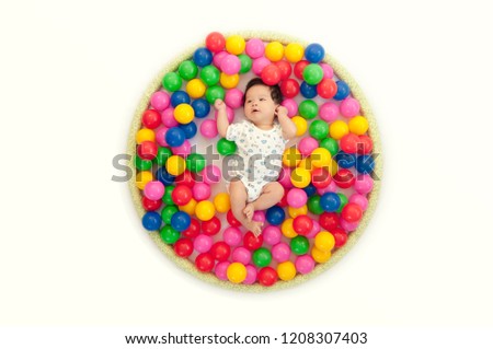 Adorable Asian Newborn Enjoy Colorful Ball World in Circle on White Background