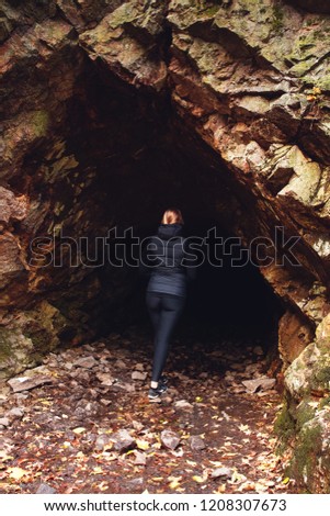 A blonde girl standing in a dark mountain forest cave. Bode Gorge (Bodetal), National Park Harz Mountains, Thale,  Saxony-Anhalt in Germany