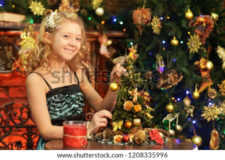 Portrait of a cute little girl near decorated Christmas tree