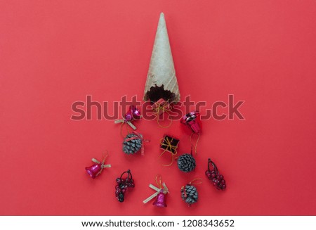 Table top view of Merry Christmas decorations & Happy new year ornaments concept.Flat lay essential difference objects gift box & ice cream cone laying on modern red paper background at office desk.