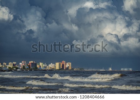 Long shot of stormy clouds over coastal city buildings
