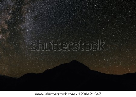 The bright stars of the Milky Way in the night sky over the mountains of the North Caucasus.