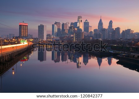 City of Philadelphia. Image of Philadelphia skyline in a morning mist, Schuylkill River and busy highway leading in to the city during sunrise.