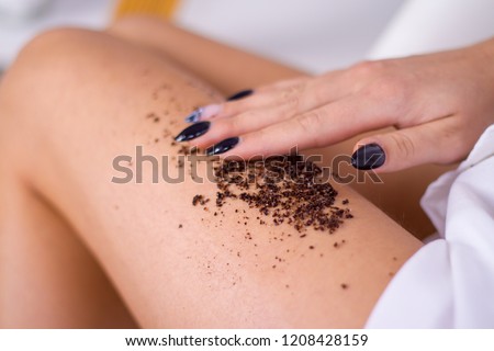 closeup woman legs with coffee massage scrub. Cosmetology, grooming, Spa cosmetic products, beauty and bikini concept. Royalty-Free Stock Photo #1208428159