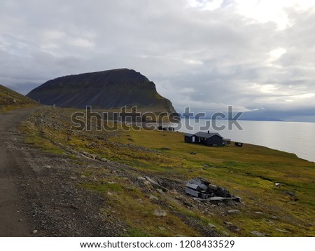 beautiful sea and mighty mountain landscape with small cabins in bear valley on svalbard