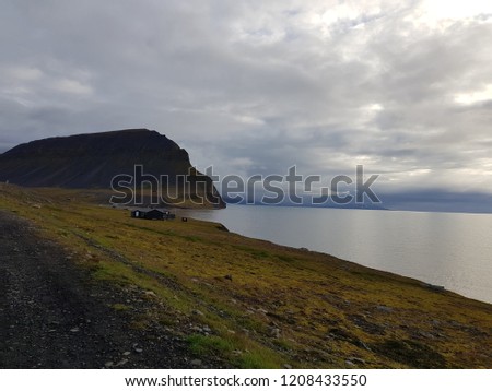 beautiful sea and mighty mountain landscape with small cabins in bear valley on svalbard