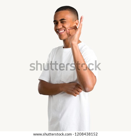 Young african american man showing an ok sign with fingers while winking an eye on isolated background