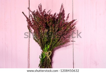 flowers heather on pink wooden background, close up,copy space