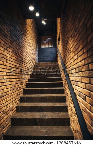 Staircase in old cellar with brick walls. Loft staircase with brick walls. Royalty-Free Stock Photo #1208457616