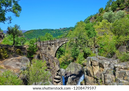 Ponte de Misarela/Misarela Bridge in Peneda-Geres National Park, Portugal. The stone bridge over the Rabagao river is surrounded by the rocky landscape, green forests and small waterfall. 09/2018 