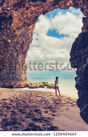 Amazing view from cave to the tropical beach with azure sea, blue sky and sands beach / Young beautiful woman enjoying a scenic ocean waves