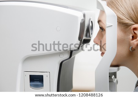 Young woman reception doctor ophthalmologist to check quality of eye vision. Concept diagnosis and treatment of myopia, hyperopia. Royalty-Free Stock Photo #1208488126