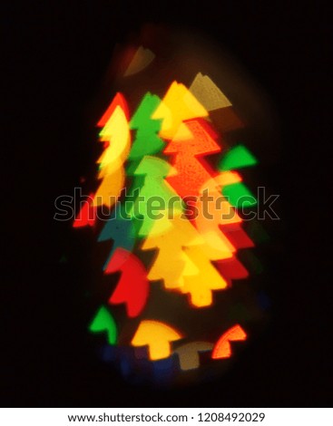 Background of blurred lights in the shape of Christmas trees on a dark. Copy space.