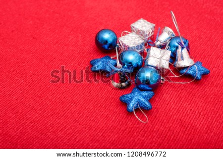 Beautiful Christmas toys of blue and silver colors on red knitted fabric background