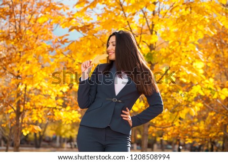 Happy successful arab businesswoman in blue suit walking in autumn park