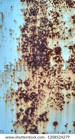 Grunge rusted background of an old metal garage door. Blue texture with brown rust