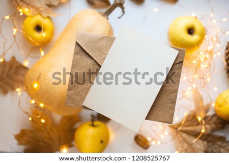 card mockup with pumpkins, ribbon, apples, lights. craft envelope, flat lay, top view