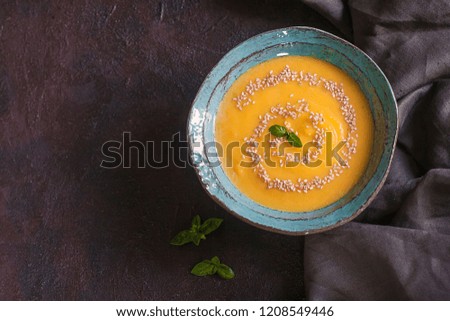 Pumpkin soup in handmade ceramic plate.