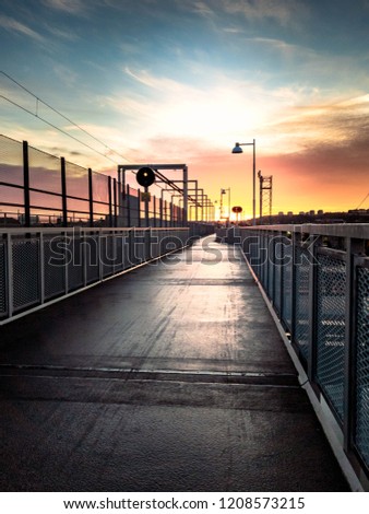 bridge with cycling track and railway track  connecting hisingen and gamlastaden in gothenburg sweden with rising sun in the pink sky bridge in gothenburg sweden with rising sun in the pink sky
